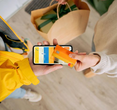 Person making contactless payment with a credit card using smartphone. Online shopping and delivery concept.